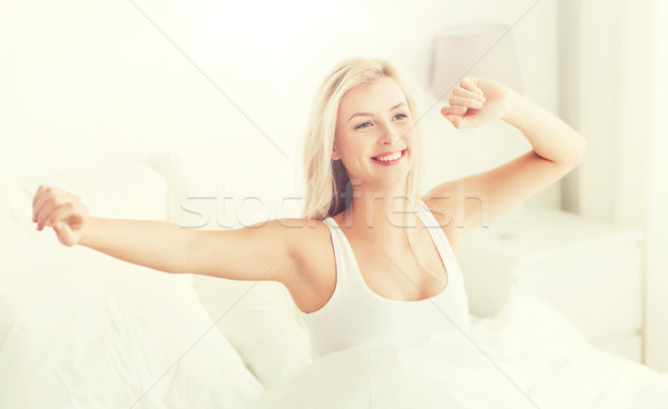 Fiatal nő nyújtás ágy felfelé alszik kényelem Stock fotó © dolgachov