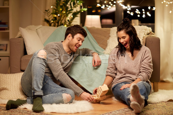happy couple playing block-stacking game at home Stock photo © dolgachov