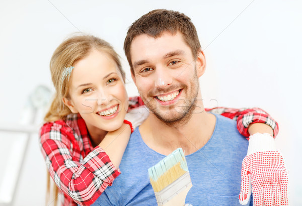 smiling couple covered with paint with paint brush Stock photo © dolgachov