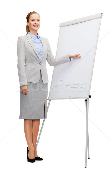 smiling businesswoman standing next to flipboard Stock photo © dolgachov