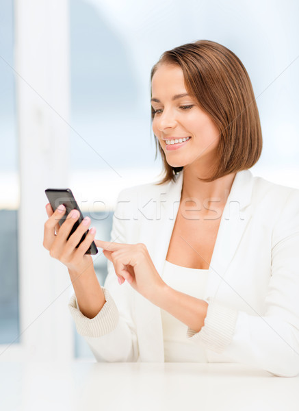 smiling businesswoman browsing in smartphone Stock photo © dolgachov