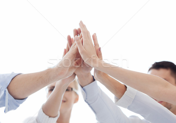 Stock photo: happy business team giving high five in office