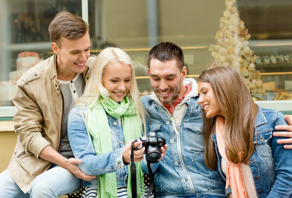 Stock photo: group of smiling friends with digital photocamera