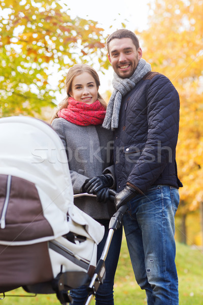 smiling couple with baby pram in autumn park Stock photo © dolgachov