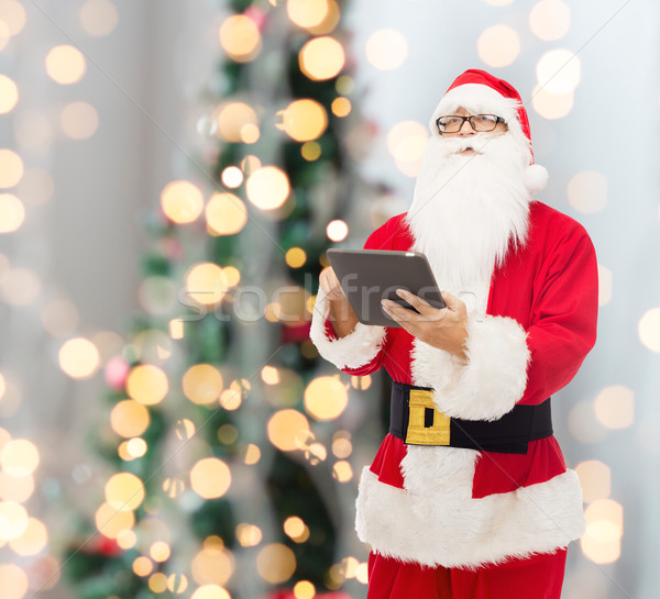 man in costume of santa claus with tablet pc Stock photo © dolgachov