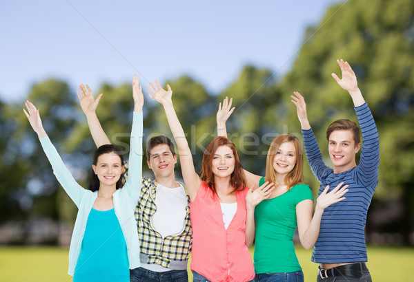 group of smiling students waving hands Stock photo © dolgachov