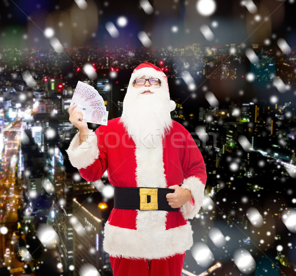 man in costume of santa claus with euro money Stock photo © dolgachov