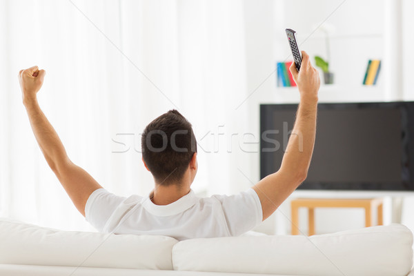 man watching tv and supporting team at home Stock photo © dolgachov