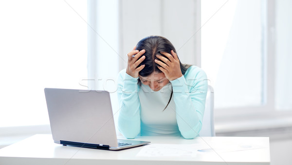 businesswoman with laptop and papers in office Stock photo © dolgachov