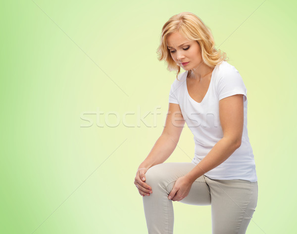 unhappy woman suffering from pain in leg at home Stock photo © dolgachov