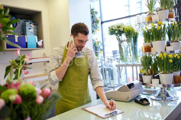 man with smartphone making notes at flower shop Stock photo © dolgachov
