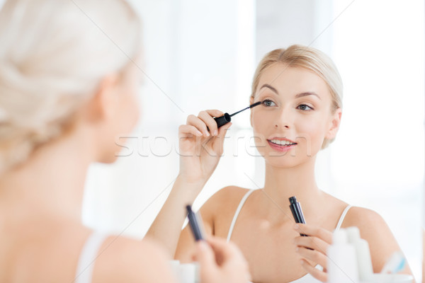 woman with mascara applying make up at bathroom Stock photo © dolgachov