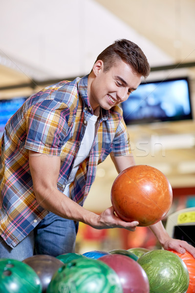 happy young man holding ball in bowling club Stock photo © dolgachov