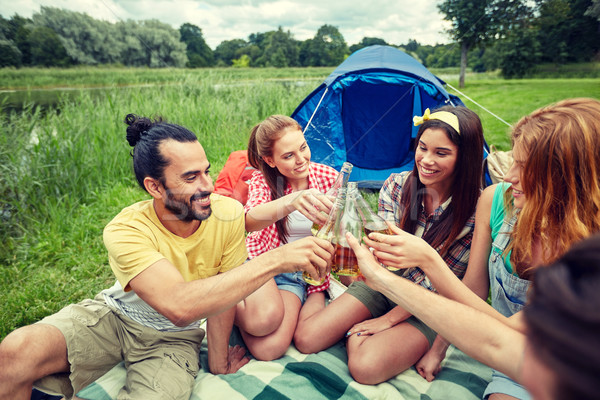 Stock photo: happy friends with tent and drinks at campsite