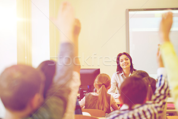 group of school kids raising hands in classroom Stock photo © dolgachov