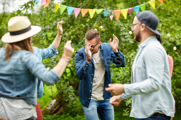 Stock photo: happy friends dancing at summer party in garden