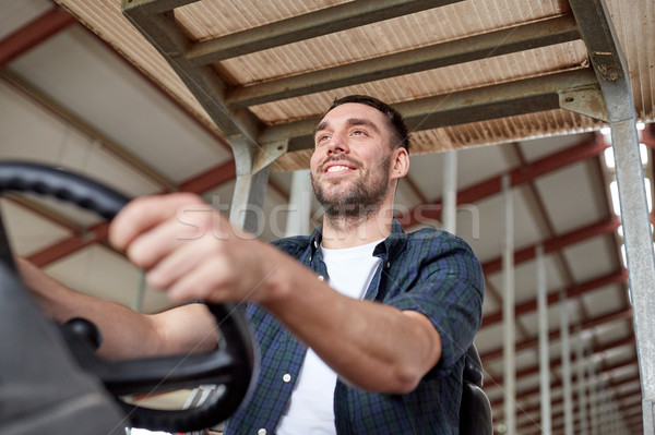 man or farmer driving tractor at farm Stock photo © dolgachov