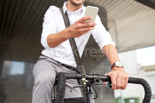 Stock photo: man with smartphone and fixed gear bike on street