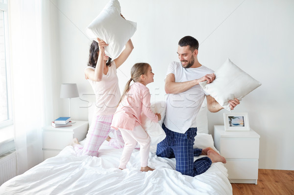 Famille heureuse bataille d'oreillers lit maison personnes famille [[stock_photo]] © dolgachov