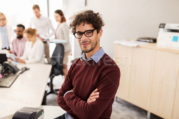 happy young man over creative team in office Stock photo © dolgachov