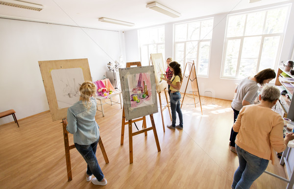 woman artists with brushes painting at art school Stock photo © dolgachov