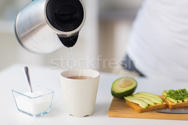 kettle pouring hot water to tea cup at home Stock photo © dolgachov