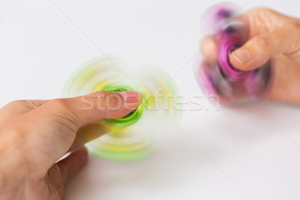 close up of hands playing with fidget spinners Stock photo © dolgachov