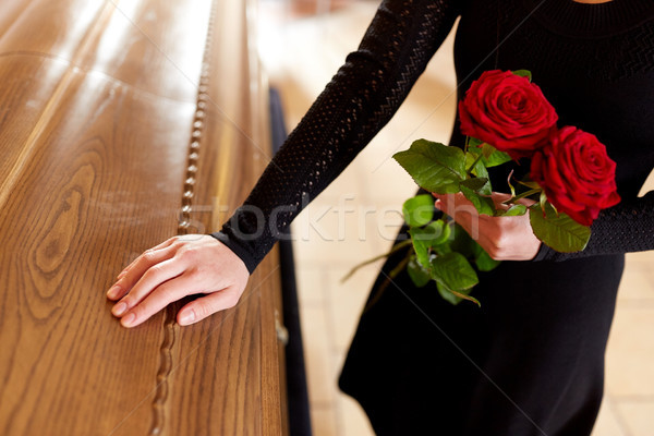 woman with red roses and coffin at funeral Stock photo © dolgachov