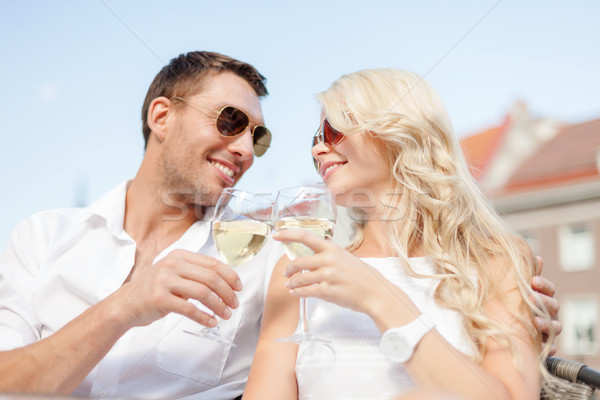 Stock photo: smiling couple in sunglasses drinking wine in cafe