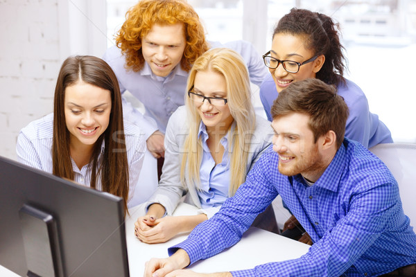 Uśmiechnięty zespół firmy patrząc monitor komputerowy działalności biuro Zdjęcia stock © dolgachov