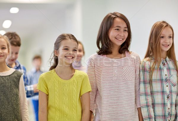 group of smiling school kids walking in corridor Stock photo © dolgachov