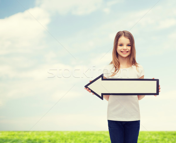 smiling girl with blank arrow pointing left Stock photo © dolgachov