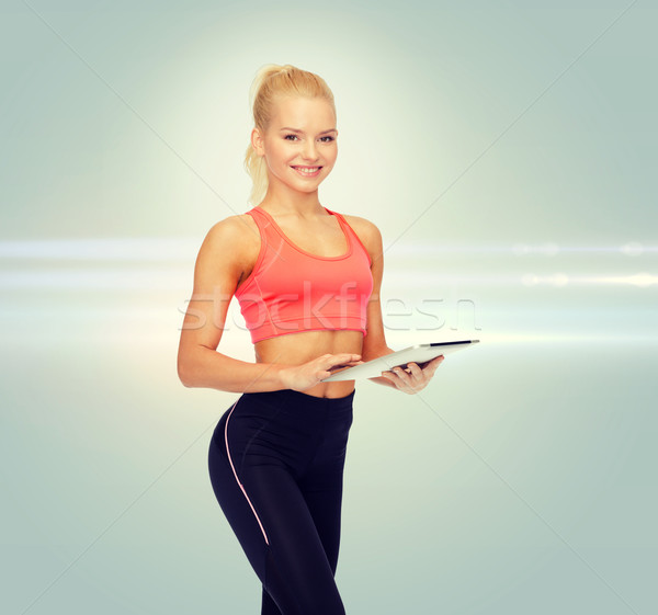 smiling sporty woman with tablet pc computer Stock photo © dolgachov