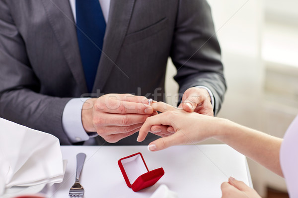 close up of man putting ring to his fiance finger Stock photo © dolgachov
