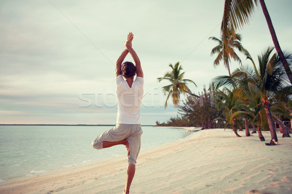 young man making yoga exercises outdoors Stock photo © dolgachov