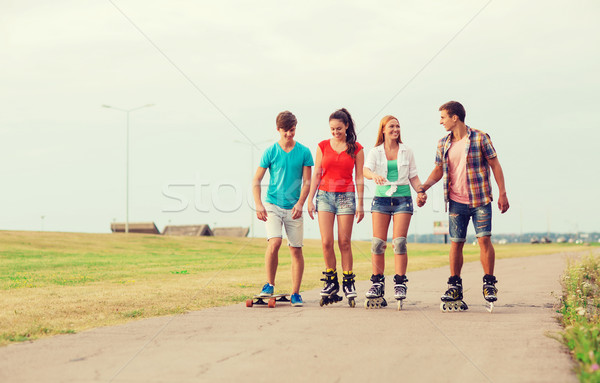 group of smiling teenagers with roller-skates Stock photo © dolgachov