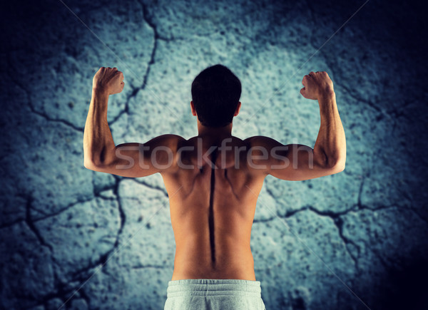 young man showing biceps and muscles Stock photo © dolgachov