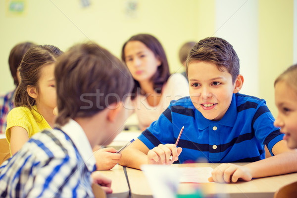 group of school kids writing test in classroom Stock photo © dolgachov