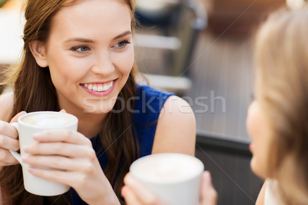 Zâmbitor femeile tinere cesti de cafea cafenea comunicare prietenie Imagine de stoc © dolgachov