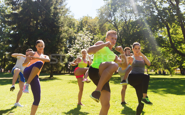 group of friends or sportsmen exercising outdoors Stock photo © dolgachov