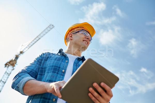 builder in hardhat with tablet pc at construction Stock photo © dolgachov