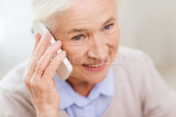 Stock photo: senior woman with smartphone calling at home