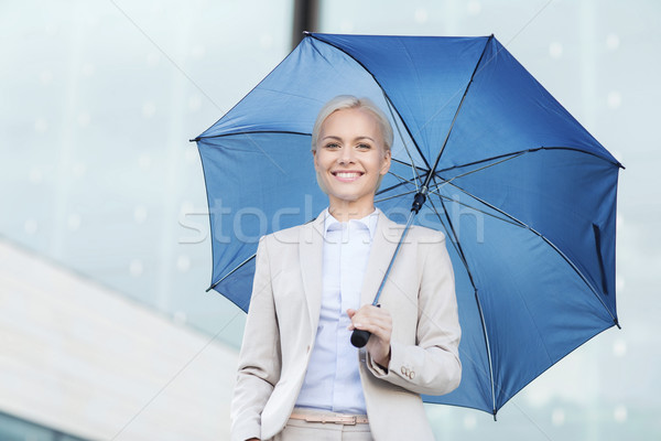 young smiling businesswoman with umbrella outdoors Stock photo © dolgachov
