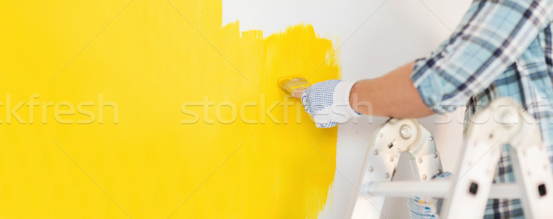 close up of male in gloves painting a wall Stock photo © dolgachov