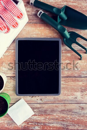 close up of tablet pc and garden tools on table Stock photo © dolgachov