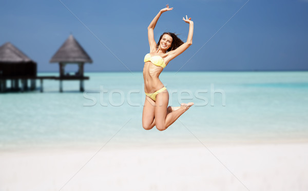 Heureux jeune femme sautant exotique plage personnes [[stock_photo]] © dolgachov