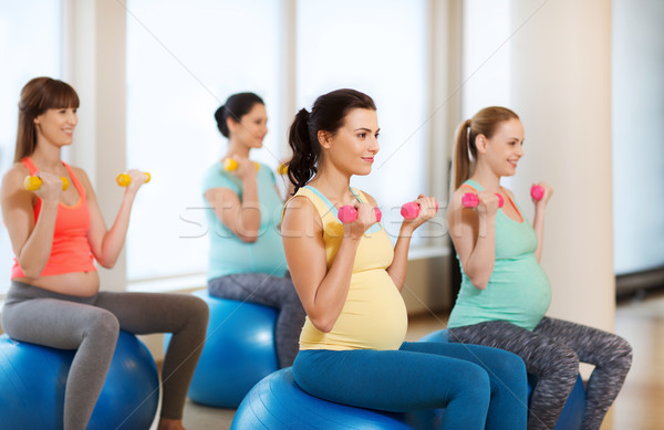 happy pregnant women exercising on fitball in gym Stock photo © dolgachov