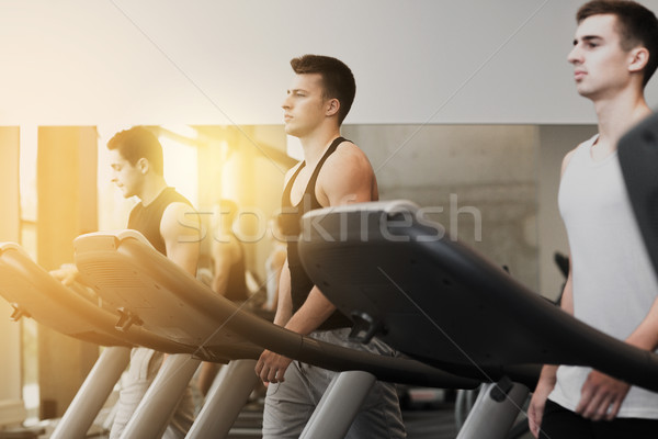 Grup bărbaţi banda de alergare sală de gimnastică sportiv Imagine de stoc © dolgachov