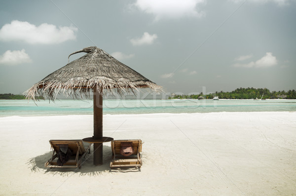 palapa and sunbeds by sea on maldives beach Stock photo © dolgachov