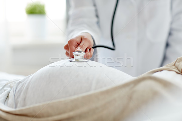 doctor with stethoscope and pregnant woman Stock photo © dolgachov